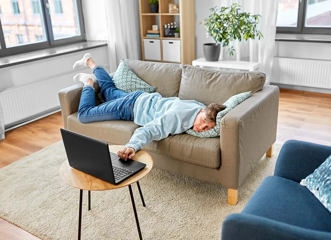 Un homme en train de calculer sur son ordinateur le temps qu'il gagne à ne pas faire le ménage